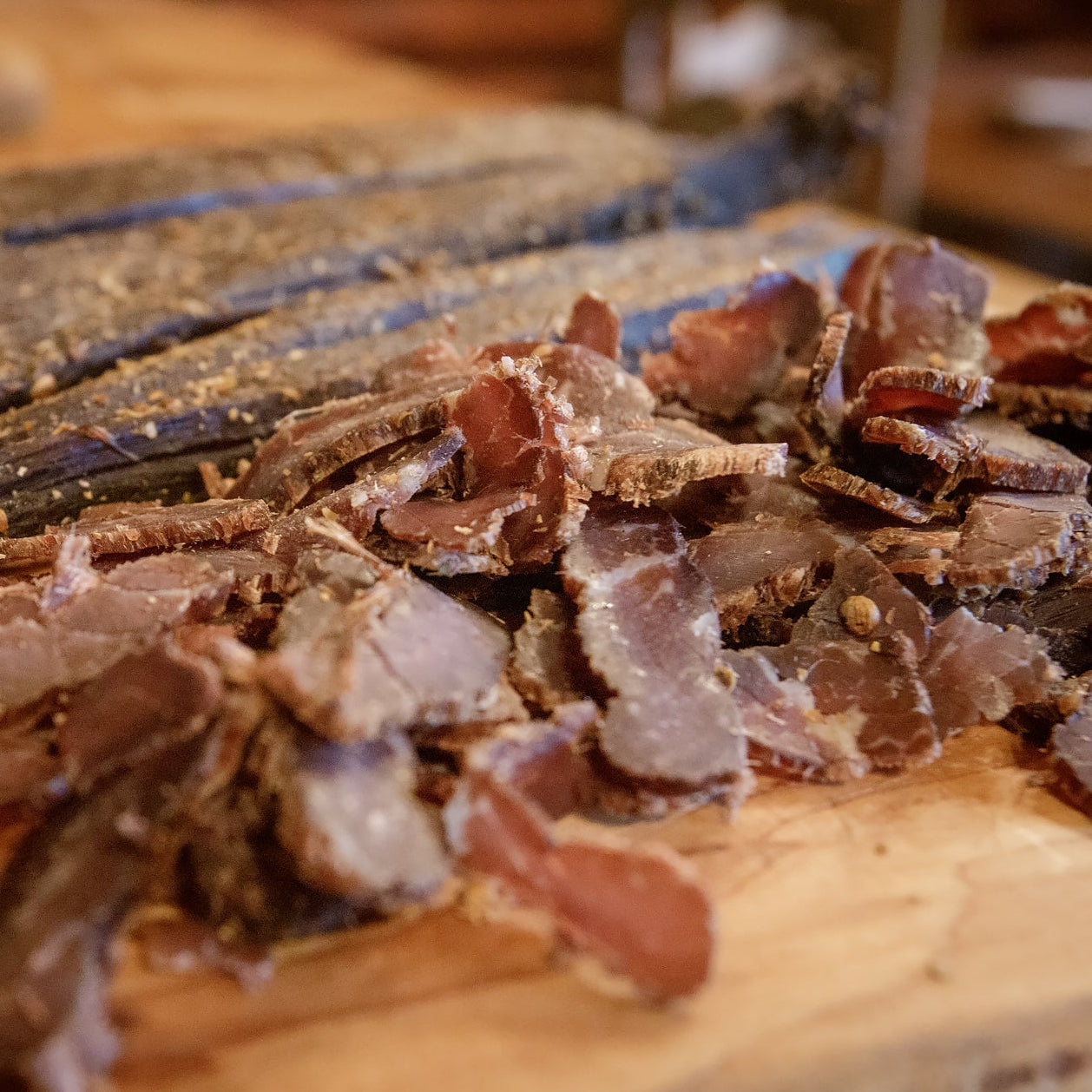 Close-up of sliced biltong on a wooden cutting board
